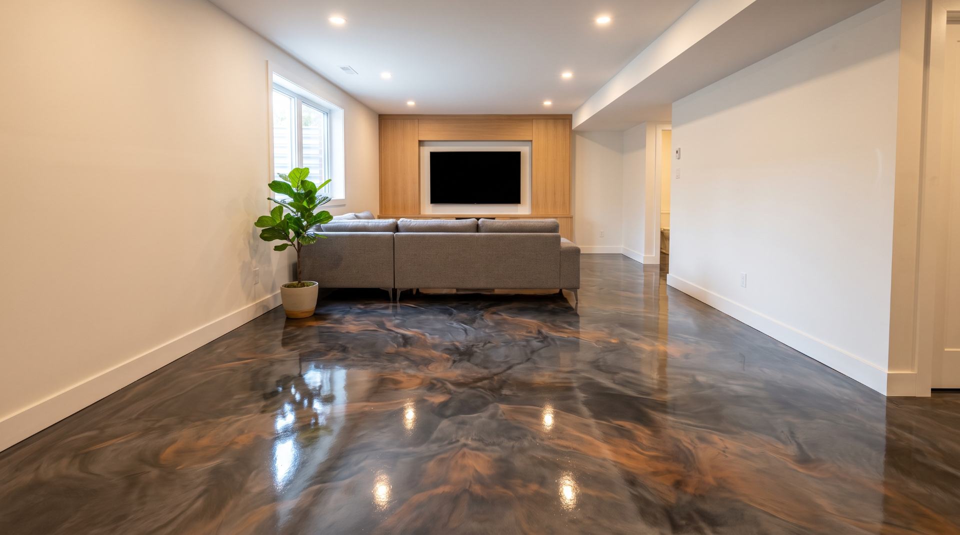 Salle familiale avec plancher époxy anthracite et bronze